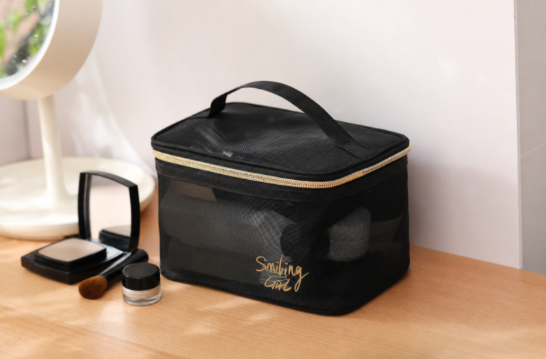 Large black nylon mesh cosmetic case with handle and gold zipper.