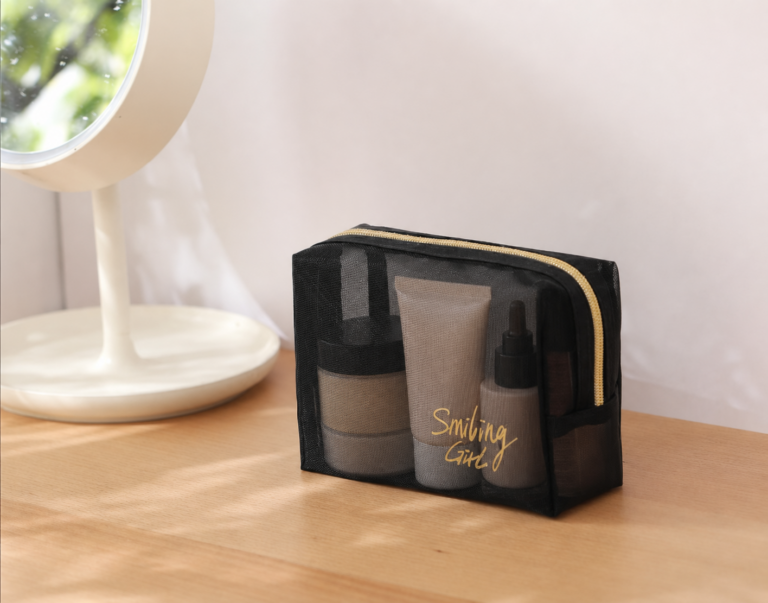 Black nylon mesh cosmetic bag set with wrist strap and gold zipper.