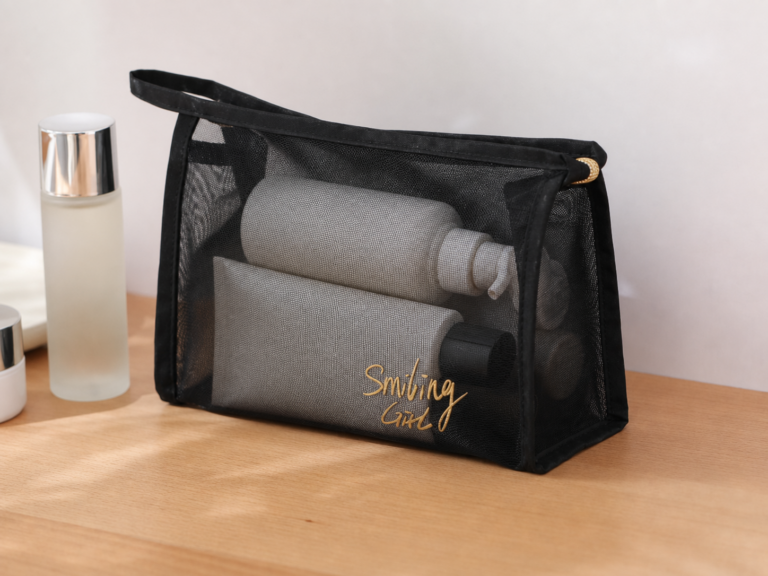 Rectangular black nylon mesh cosmetic pouch with wrist strap and gold zipper.