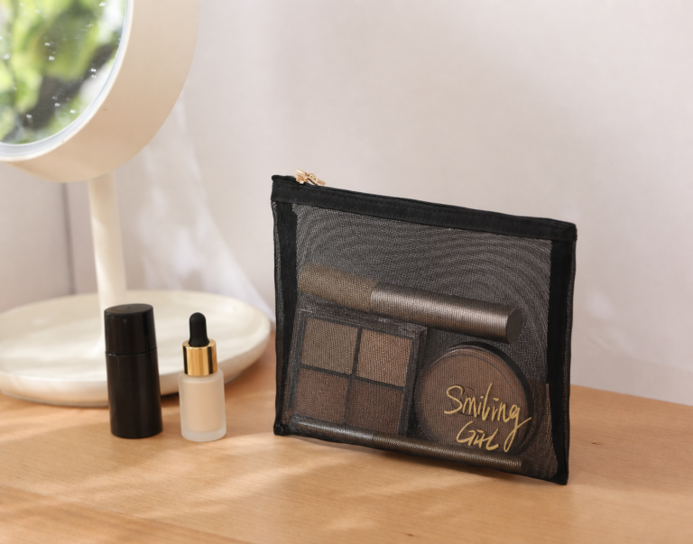 Flat black nylon mesh cosmetic pouch with top zipper.